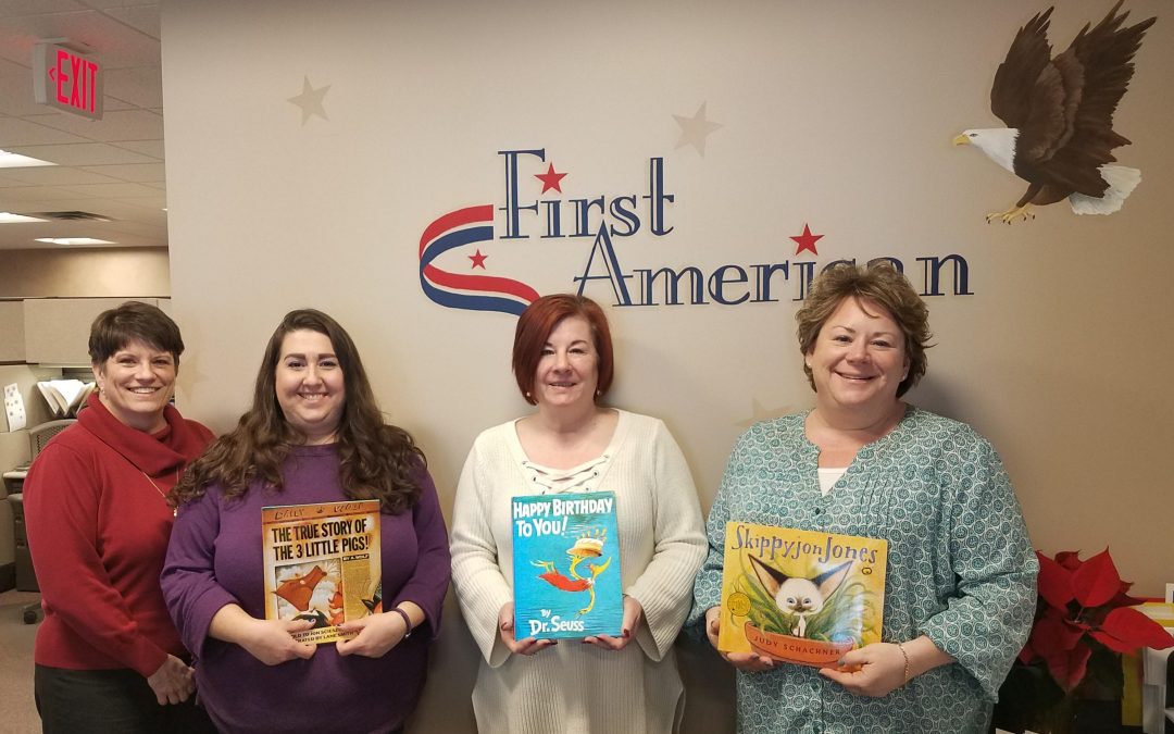 employees holding book for read across america
